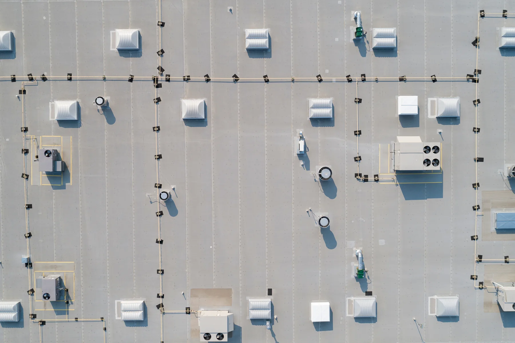 Top-down aerial of a vast industrial roof showing a regular grid of rooftop ventilation and HVAC units.
