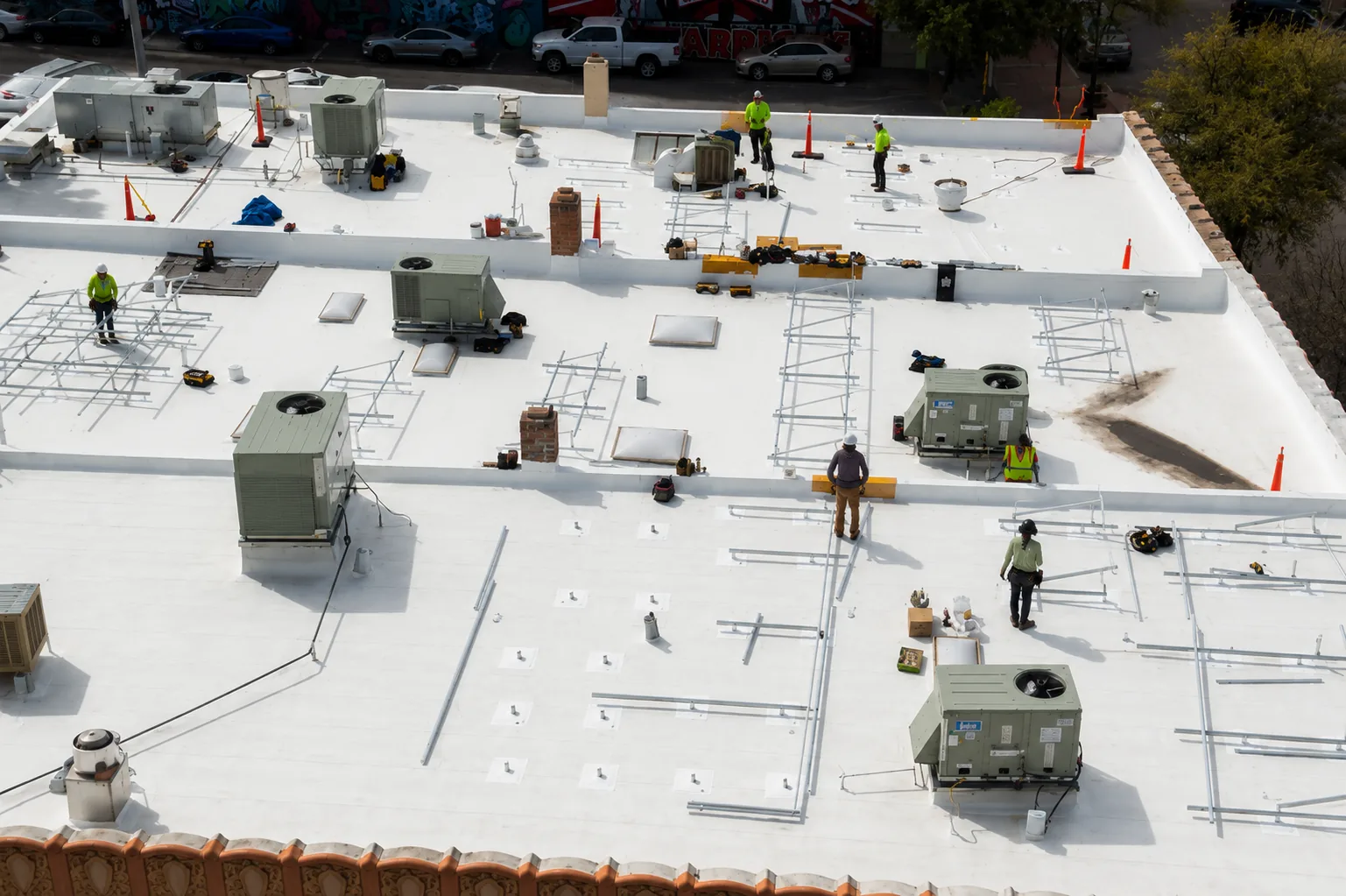 A Roofix crew working across a large commercial flat roof with HVAC units and safety equipment